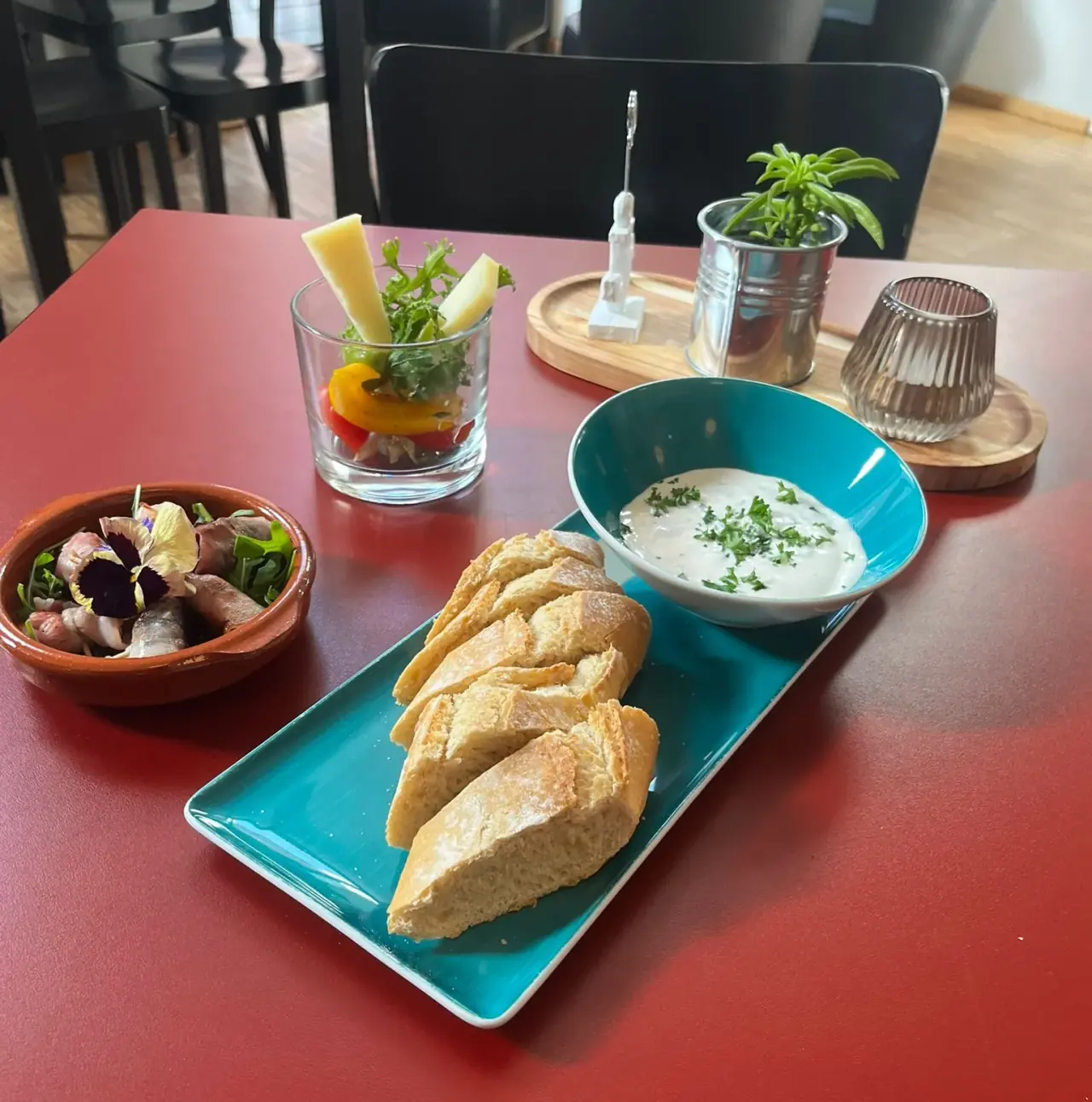 Aufgeschnittenes Baguette mit Dip, Oliven und eingelegtem Gemüse im Café ElbFaire