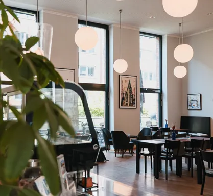 Heller Gastraum des Café ElbFaire mit Bistrotischen und Fensterfront zur HafenCity